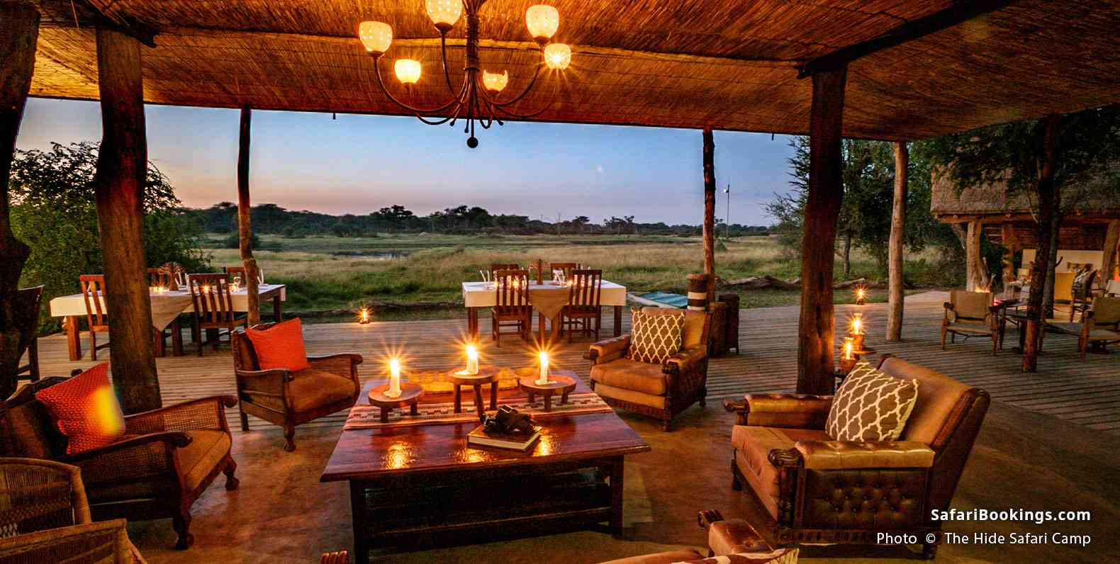 Illuminated terrace of The Hide Safari Camp at dusk