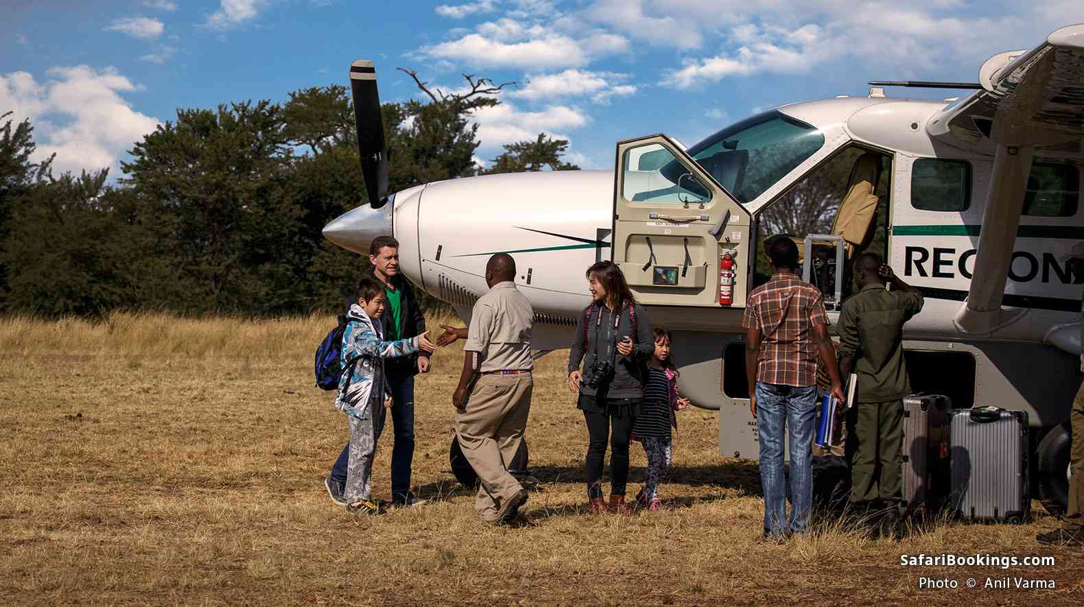 Group of travelers disembarking a small plane at the Kogatende airstrip
