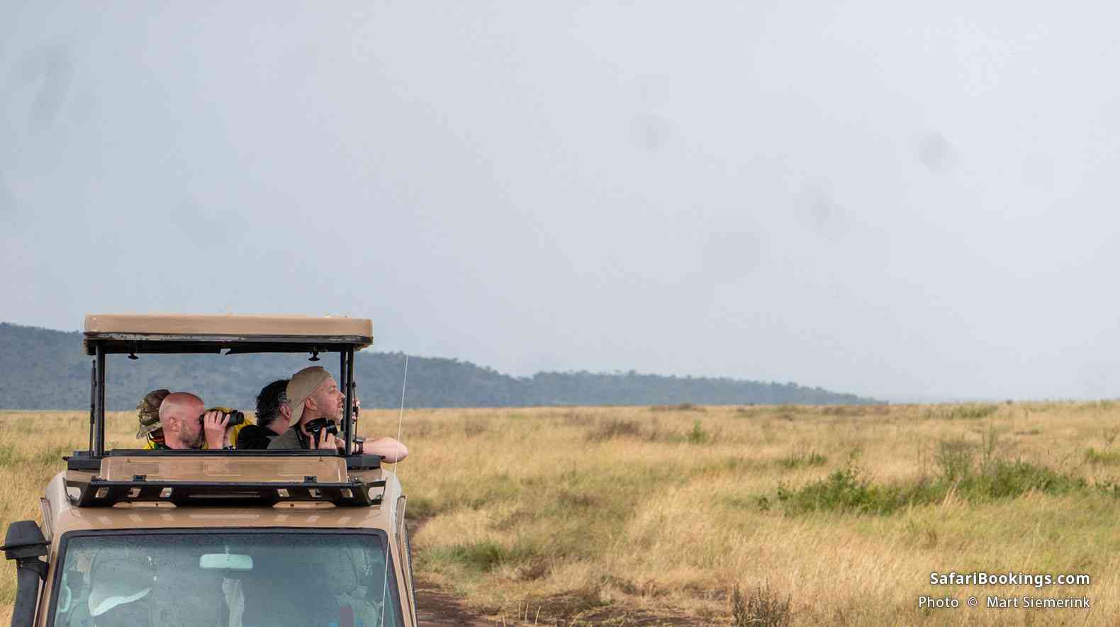 Travelers viewing wildlife from a pop-up-roof safari vehicle in Serengeti National Park