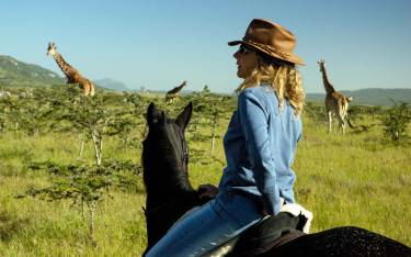 Horseback rider watching giraffes