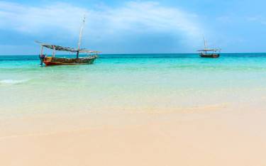 Small dhows on the azure blue waters surrounding the island