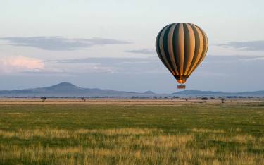 Hot-air balloon flying low over the Serengeti plains
