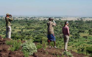 Traveler with guides overlooking the plains