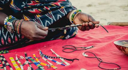 Maasai vendor selling beadwork on the beach