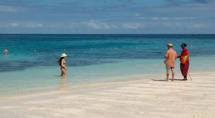 Visitor talking to a Maasai man on the beach
